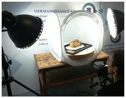 Captura fotográfica con modelo ubicado sobre plataforma giratoria dentro de una caja de luz iluminada por dos focos